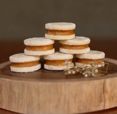 Alfajores peruanos empilhados em tábua de madeira, indicação da Vestidas de Branco para casamentos